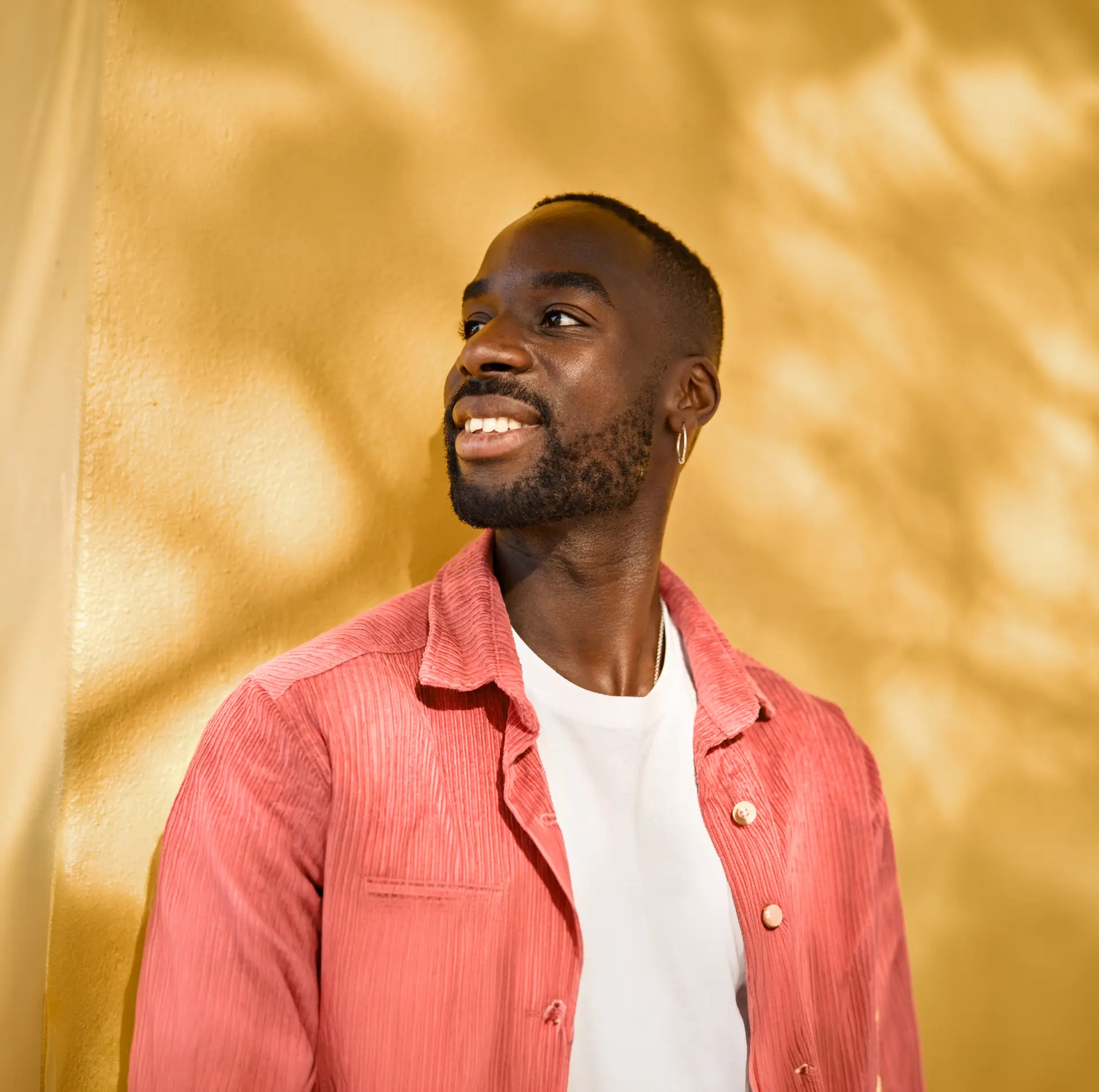 A man smiling warmly in soft golden light